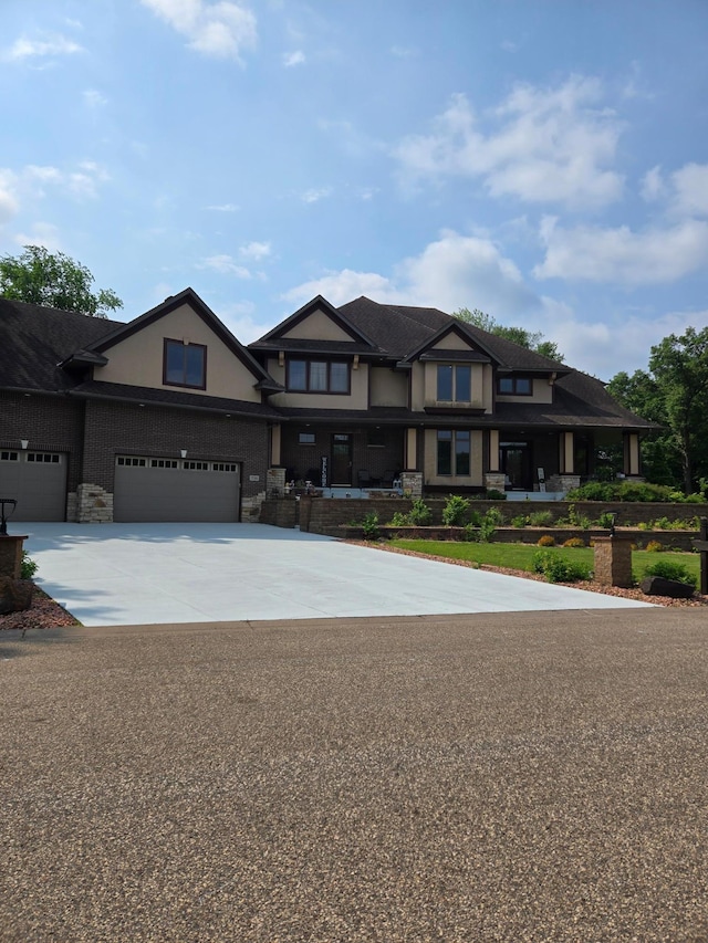 716 169th Ln NE, Ham Lake, MN 55304 - view of front of house with driveway, stone siding, stucco siding, and a garage