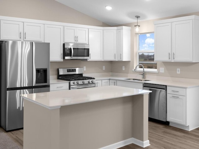 9773 32nd St NE, Saint Michael, MN 55376 - kitchen featuring stainless steel appliances, vaulted ceiling, white cabinetry, wood finished floors, and a center island