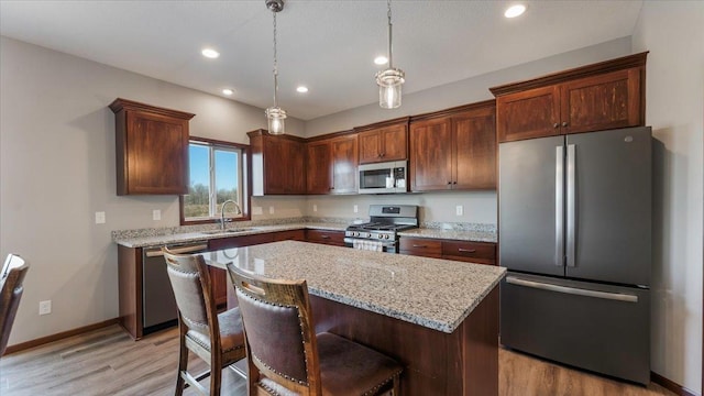991 45th Ave NE, Saint Cloud, MN 56304 - kitchen with appliances with stainless steel finishes, light wood finished floors, a center island, recessed lighting, and light stone counters