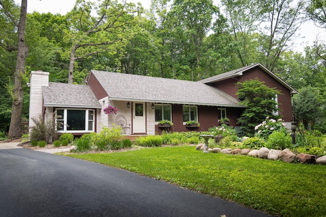 58280 County Road 21, Zumbro Falls, MN 55991 - view of front of home with a front lawn, a chimney, a shingled roof, and covered porch