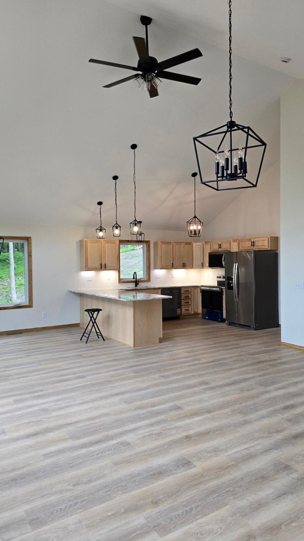 17541 Mitchell Lake Rd, Fifty Lakes, MN 56448 - kitchen featuring stainless steel fridge, light brown cabinets, light wood-style floors, a chandelier, and range with electric stovetop