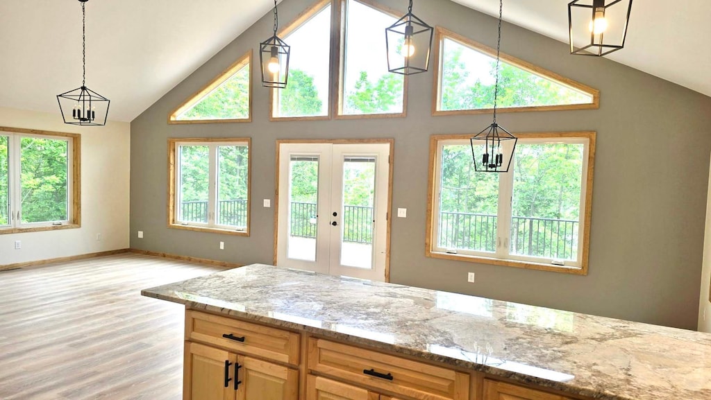 17541 Mitchell Lake Rd, Fifty Lakes, MN 56448 - kitchen featuring light stone counters, light wood-type flooring, french doors, a chandelier, and high vaulted ceiling