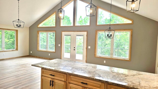 17541 Mitchell Lake Rd, Fifty Lakes, MN 56448 - kitchen featuring light stone counters, light wood-type flooring, french doors, a chandelier, and high vaulted ceiling