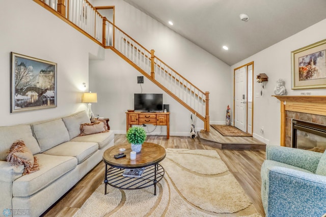 3327 23rd Ave S, Fargo, ND 58103 - living room with stairs, wood finished floors, recessed lighting, a tile fireplace, and high vaulted ceiling