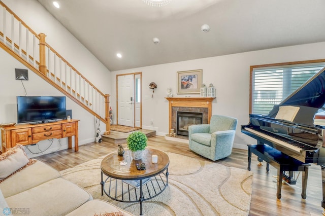 3327 23rd Ave S, Fargo, ND 58103 - living area featuring stairs, vaulted ceiling, light wood-type flooring, recessed lighting, and a tile fireplace