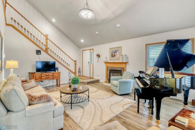 3327 23rd Ave S, Fargo, ND 58103 - living area featuring vaulted ceiling, stairway, light wood finished floors, a tiled fireplace, and recessed lighting