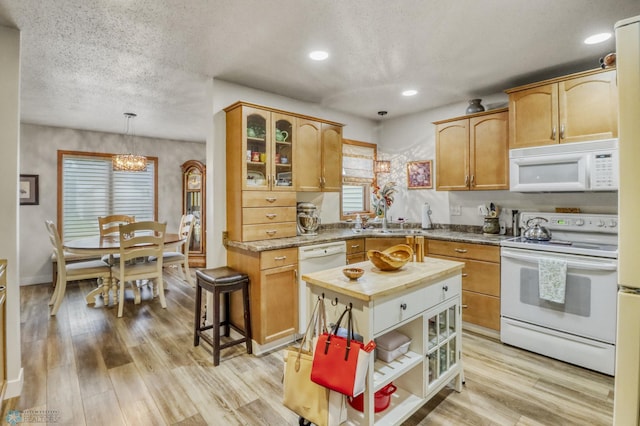 3327 23rd Ave S, Fargo, ND 58103 - kitchen with white appliances, a textured ceiling, a chandelier, glass insert cabinets, and light wood finished floors