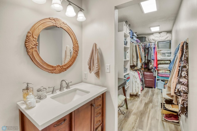 3327 23rd Ave S, Fargo, ND 58103 - bathroom with vanity, wood finished floors, and a spacious closet