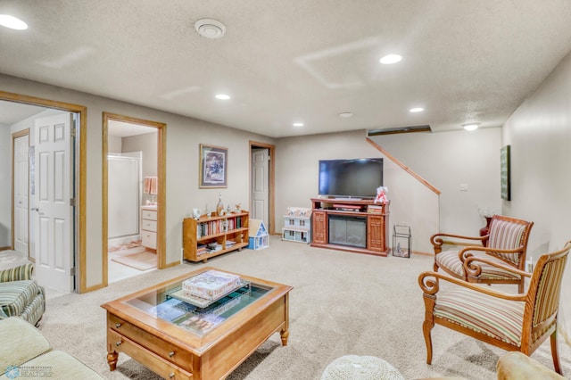 3327 23rd Ave S, Fargo, ND 58103 - carpeted living area with recessed lighting, a glass covered fireplace, and a textured ceiling