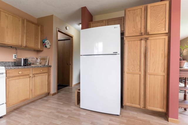 603 7th Ave, Osakis, MN 56360 - kitchen featuring freestanding refrigerator, light wood-style floors, and stone counters