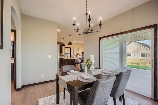 3483 Kady Ave NE, Saint Michael, MN 55376 - dining room with a chandelier, light wood-type flooring, arched walkways, and high vaulted ceiling