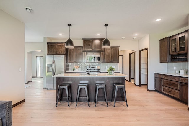 3483 Kady Ave NE, Saint Michael, MN 55376 - kitchen featuring appliances with stainless steel finishes, arched walkways, a breakfast bar area, light wood-type flooring, and recessed lighting