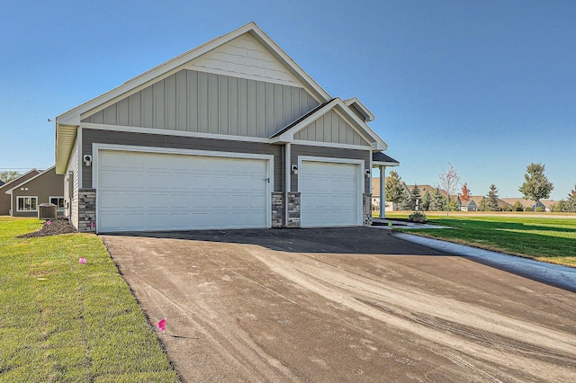 3483 Kady Ave NE, Saint Michael, MN 55376 - view of front of home featuring board and batten siding, stone siding, a front lawn, and driveway