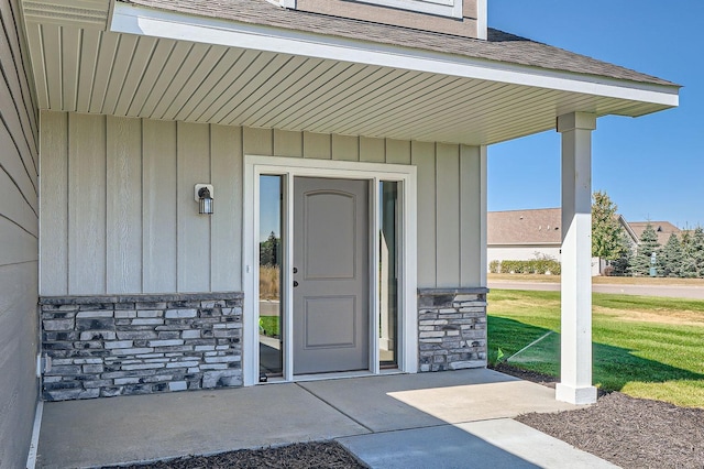 3483 Kady Ave NE, Saint Michael, MN 55376 - property entrance featuring stone siding, roof with shingles, a yard, and board and batten siding