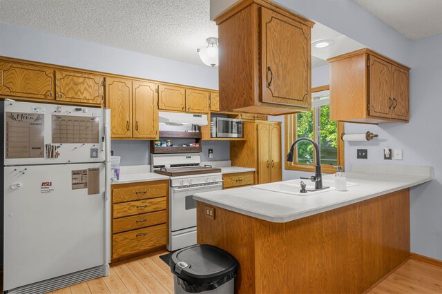 505 Brookview Ln SW, Isanti, MN 55040 - kitchen featuring white appliances, under cabinet range hood, a peninsula, light wood finished floors, and light countertops