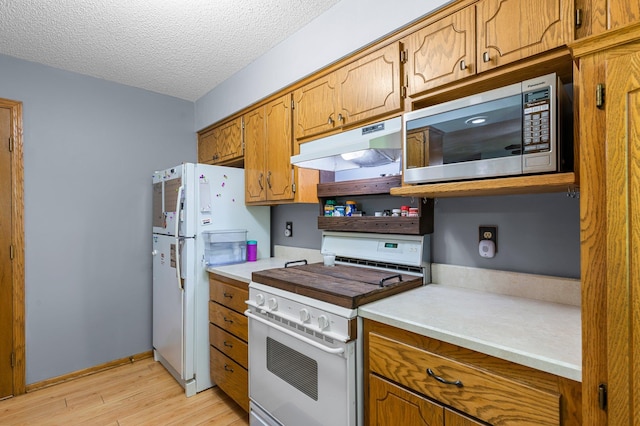 505 Brookview Ln SW, Isanti, MN 55040 - kitchen featuring white appliances, under cabinet range hood, light wood finished floors, brown cabinetry, and a textured ceiling