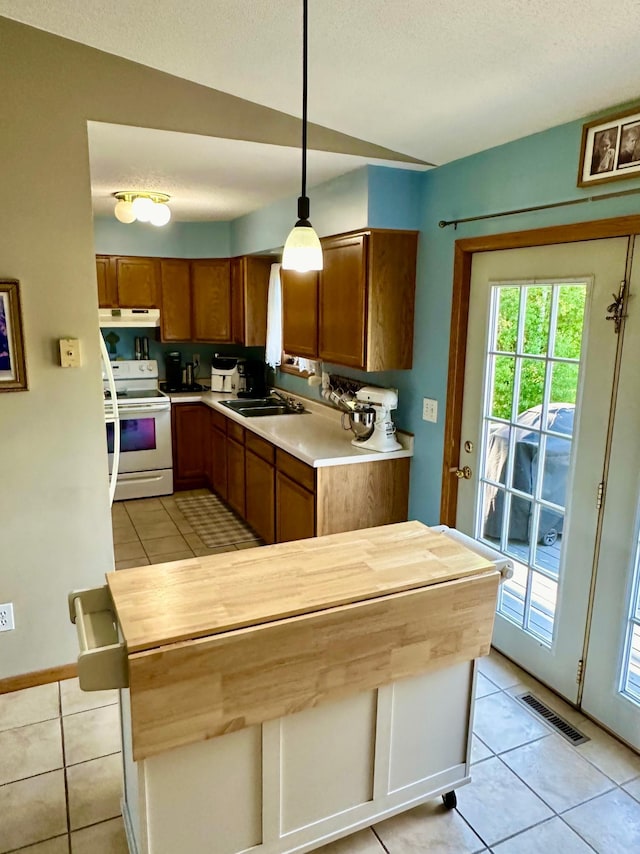 5735 County Road 1, Littlefork, MN 56653 - kitchen with white electric stove, light tile patterned floors, under cabinet range hood, brown cabinets, and butcher block counters