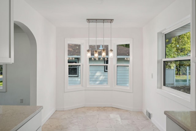 242 Butler Ave W, West Saint Paul, MN 55118 - unfurnished dining area with light marble finish flooring and arched walkways