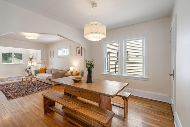 1067 Van Buren Ave, Saint Paul, MN 55104 - dining space featuring arched walkways, healthy amount of natural light, and wood-type flooring