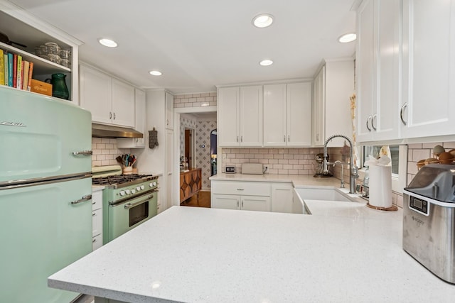 4837 Diane Dr, Minnetonka, MN 55343 - kitchen with freestanding refrigerator, high end stove, under cabinet range hood, white cabinetry, and recessed lighting