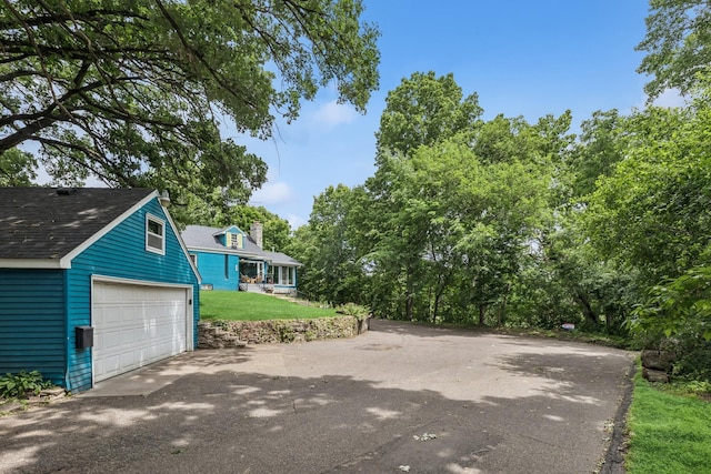 4837 Diane Dr, Minnetonka, MN 55343 - view of side of property featuring a garage, a shingled roof, a chimney, and a lawn