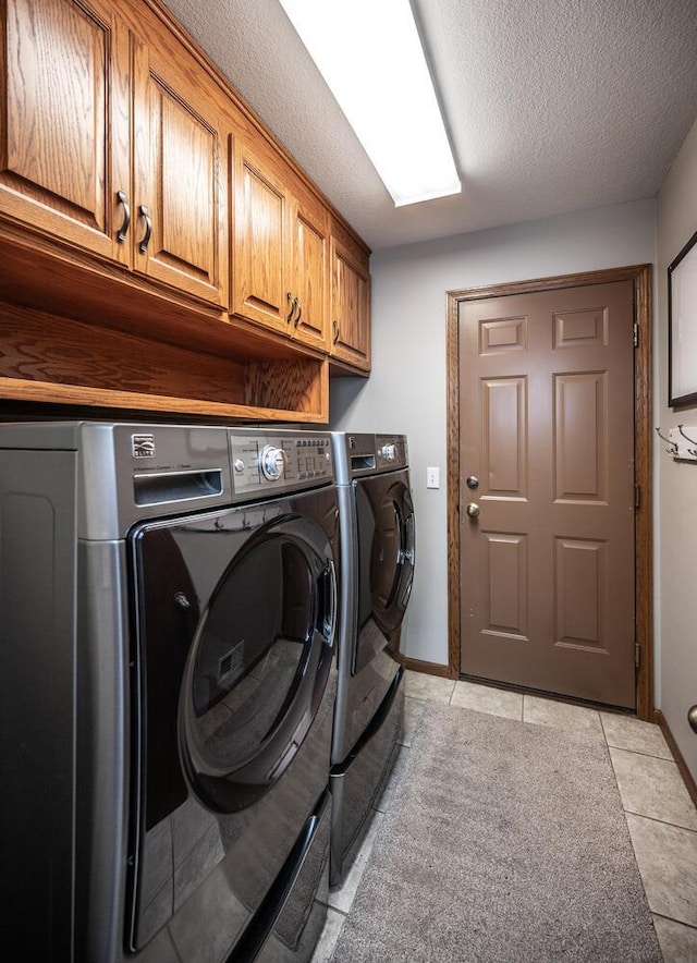 452 Spruce St, Shakopee, MN 55379 - laundry area featuring washing machine and clothes dryer, cabinet space, a textured ceiling, and light tile patterned floors