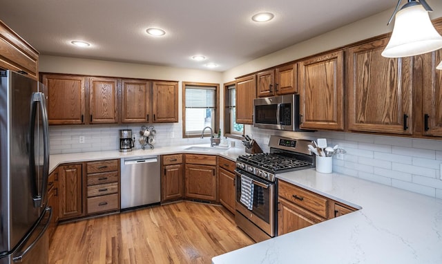 452 Spruce St, Shakopee, MN 55379 - kitchen with appliances with stainless steel finishes, brown cabinetry, backsplash, light wood-style floors, and recessed lighting