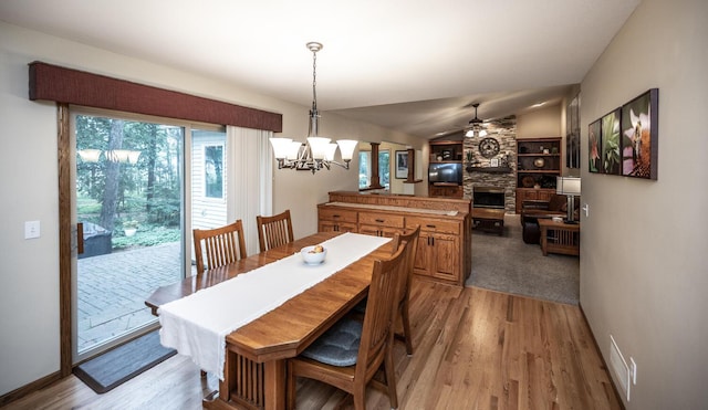 452 Spruce St, Shakopee, MN 55379 - dining area with light wood finished floors, a stone fireplace, a chandelier, a ceiling fan, and lofted ceiling