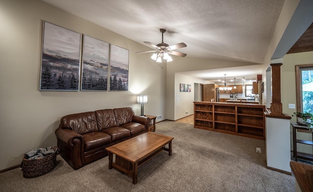 452 Spruce St, Shakopee, MN 55379 - living room featuring light carpet, ceiling fan, a chandelier, vaulted ceiling, and decorative columns