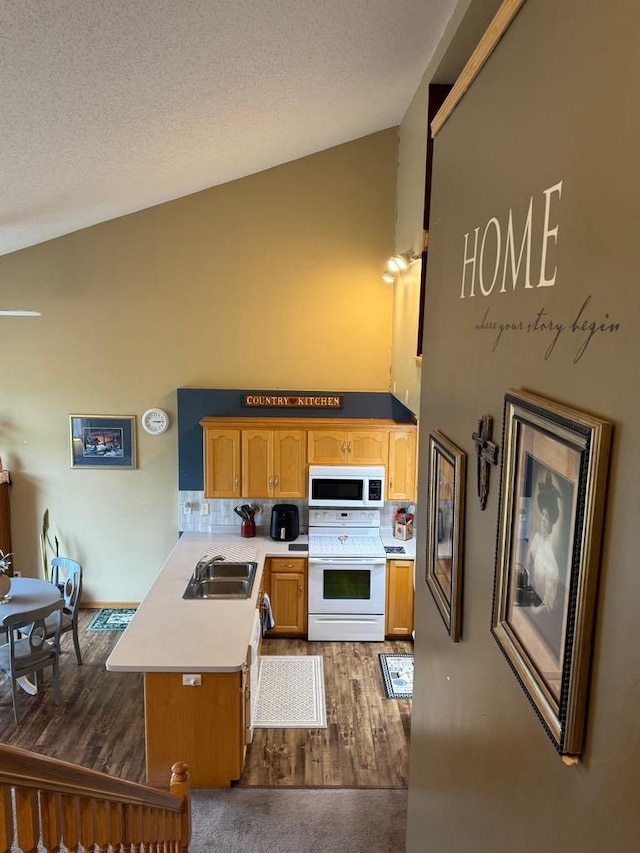 110 Glenshire Blvd S, Watkins, MN 55389 - kitchen featuring white appliances, vaulted ceiling, a peninsula, light countertops, and dark wood-style flooring