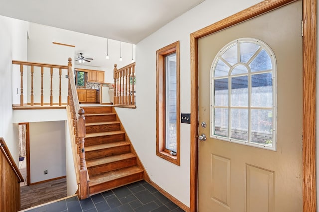 733 Meadow Dr, Hudson, WI 54016 - entrance foyer featuring a ceiling fan, plenty of natural light, dark tile patterned flooring, and stairway