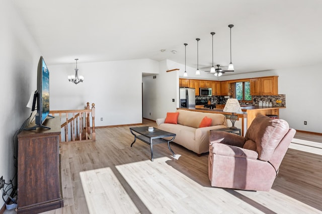 733 Meadow Dr, Hudson, WI 54016 - living room featuring a chandelier, light wood-style flooring, vaulted ceiling, and ceiling fan