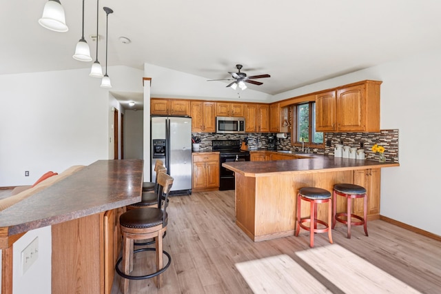 733 Meadow Dr, Hudson, WI 54016 - kitchen with appliances with stainless steel finishes, decorative backsplash, brown cabinets, a ceiling fan, and light wood-style floors