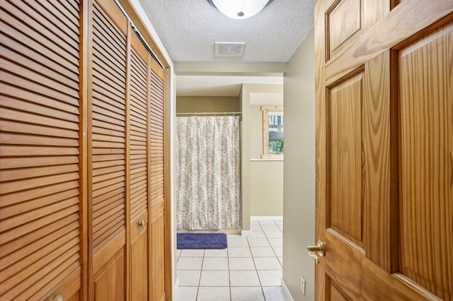 733 Meadow Dr, Hudson, WI 54016 - bathroom with a closet, tile patterned flooring, a textured ceiling, and curtained shower