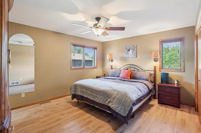 733 Meadow Dr, Hudson, WI 54016 - bedroom with light wood finished floors, arched walkways, and a ceiling fan