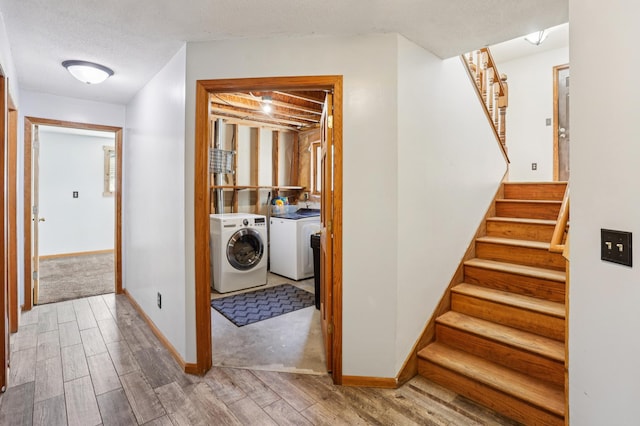 733 Meadow Dr, Hudson, WI 54016 - stairs with washing machine and clothes dryer, wood finished floors, and a textured ceiling