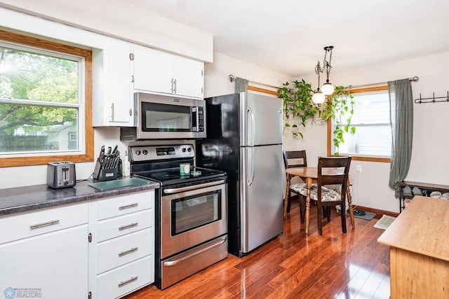1124 15th St N, Moorhead, MN 56560 - kitchen featuring appliances with stainless steel finishes, wood finished floors, white cabinetry, and dark countertops