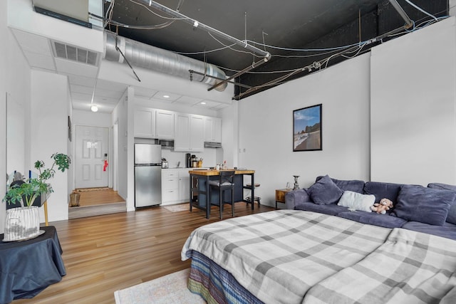 431 7th St Unit 2605, Minneapolis, MN 55415 - bedroom featuring freestanding refrigerator and light wood-style floors