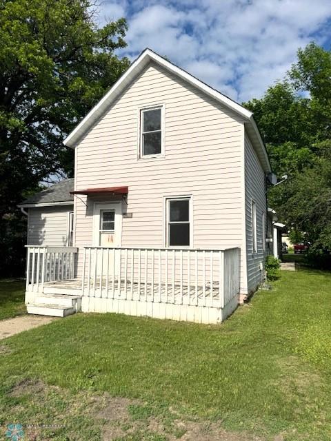 310 1st St SW, Mahnomen, MN 56557 - view of side of property featuring a yard and a wooden deck