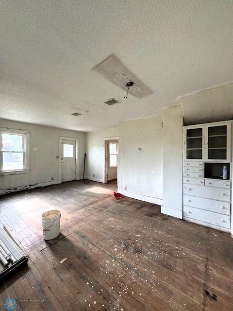 310 1st St SW, Mahnomen, MN 56557 - unfurnished living room with a textured ceiling and wood-type flooring