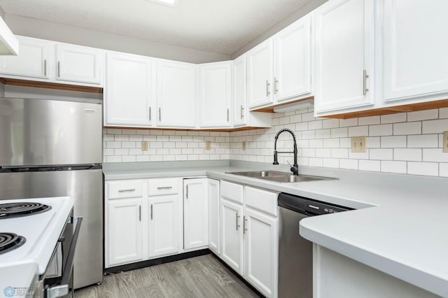 3050 18th St S, Fargo, ND 58103 - kitchen featuring appliances with stainless steel finishes, light countertops, white cabinets, tasteful backsplash, and light wood-style floors