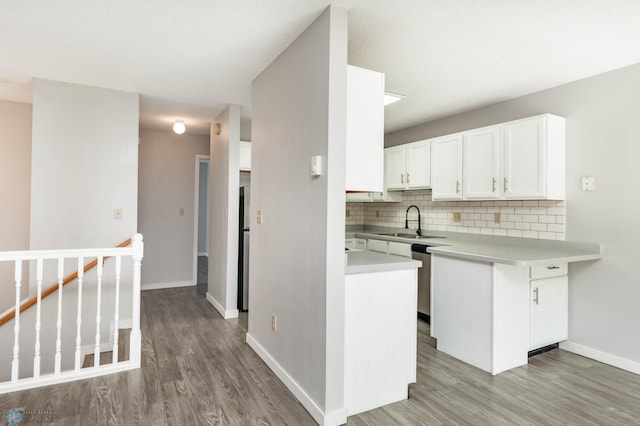 3050 18th St S, Fargo, ND 58103 - kitchen with decorative backsplash, light wood-style floors, white cabinets, light countertops, and a peninsula