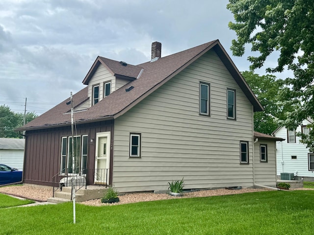720 Fir Ave, Bird Island, MN 55310 - back of property with a chimney, a lawn, a shingled roof, and board and batten siding