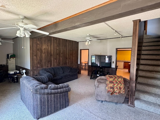 720 Fir Ave, Bird Island, MN 55310 - carpeted living room with ceiling fan, a textured ceiling, stairs, and wooden walls