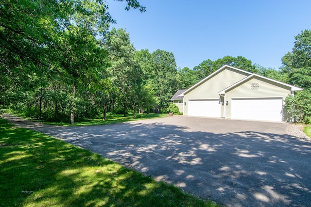 1069 134th St SW, Sylvan Twp, MN 56473 - view of property exterior featuring asphalt driveway, a garage, and a lawn