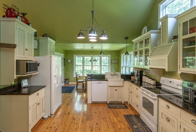 1069 134th St SW, Sylvan Twp, MN 56473 - kitchen featuring white appliances, dark countertops, a peninsula, and healthy amount of natural light