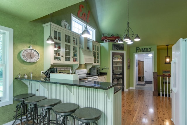 1069 134th St SW, Sylvan Twp, MN 56473 - kitchen with white appliances, pendant lighting, a breakfast bar, vaulted ceiling, and dark countertops