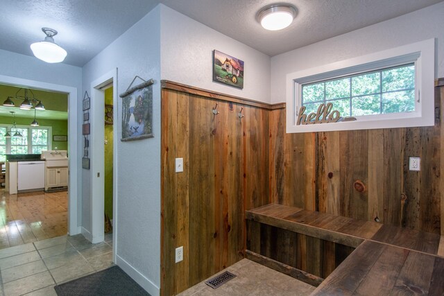 1069 134th St SW, Sylvan Twp, MN 56473 - mudroom featuring a textured ceiling and wooden walls