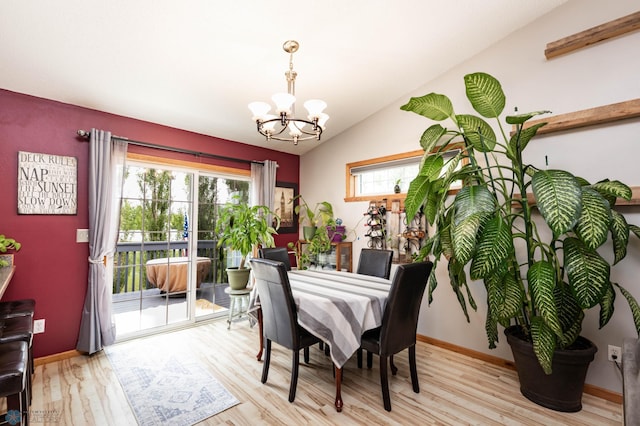 106 12th St NE, Barnesville, MN 56514 - dining area with a chandelier, light wood-style floors, and vaulted ceiling