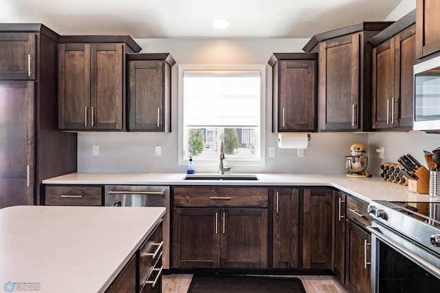 4701 11th St W, West Fargo, ND 58078 - kitchen with dark brown cabinetry, stainless steel appliances, light countertops, recessed lighting, and light wood-style floors